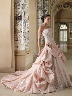 a woman in a pink wedding dress posing for the camera