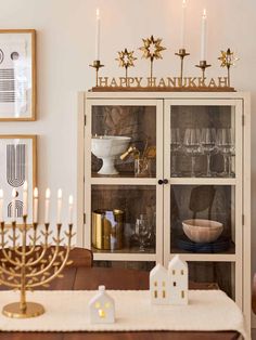 a hanukkah menorah is displayed in front of a china cabinet