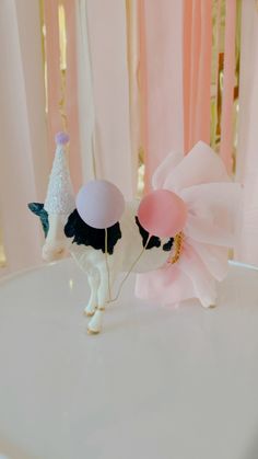 there is a cake topper with a cow on it and balloons in the air