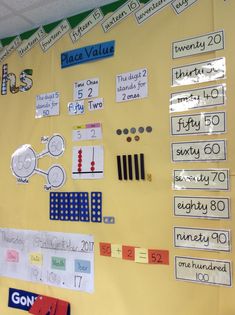 a bulletin board with numbers and place value on it in a school classroom setting that is yellow