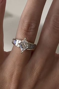 a woman's hand with a diamond ring on it