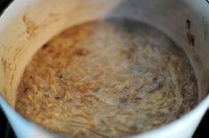 a pot filled with brown liquid sitting on top of a stove