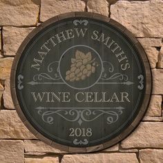 a wine cellar sign mounted to the side of a stone wall