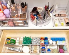 two drawers filled with makeup and beauty products on top of a counter next to each other