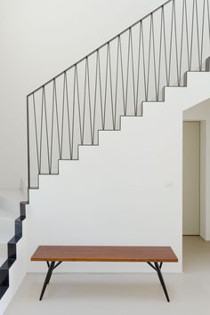 a wooden bench sitting in front of a stair case