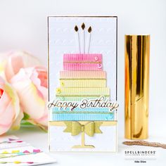 a birthday card with a cake on it and flowers in the background, next to a gold vase