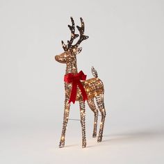 a lighted reindeer with a red bow on it's antlers is standing in front of a white background