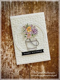 a handmade birthday card with flowers in a vase on top of a wooden table