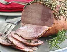 sliced ham on a plate with a fork and knife