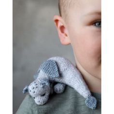 a young boy wearing a knitted elephant scarf