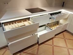 an open drawer in the middle of a kitchen