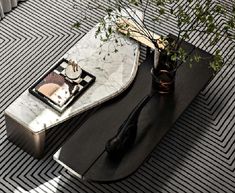 a living room with a marble coffee table and plant on it's end table