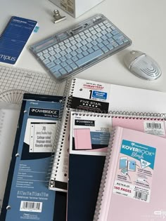 several binders and notebooks on a desk with a keyboard