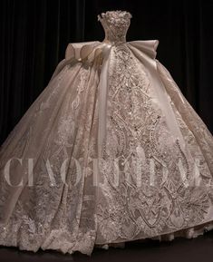 a white wedding dress on display in front of a black background