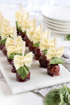 small appetizers are arranged on a plate with toothpicks in the shape of flowers