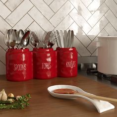 red kitchen canisters with spoons and knives