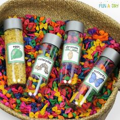 three glass bottles filled with colorful confetti on top of a bed of shredded paper