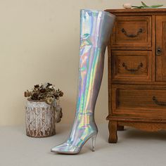 These holographic thigh high boots are sure to turn heads! They have a pointed toe and stiletto heels. and they zip up the back for a snug fit. They're also lined with plush fabric for a comfortable wear.Plus. they come in the most eye-catching silver hue. Whether you're hitting the club or just strutting your stuff around town. these boots are sure to get you noticed. So add them to your wardrobe and get ready to make a statement! Upper: Microfiber Lining: Short Plush Outsole: Rubber Toe: Point Metallic Fitted Heeled Boots With Pointed Toe, Metallic Fitted Boots For Night Out, Fitted Metallic Boots For Night Out, Fitted Metallic Winter Boots, Party Metallic Fitted Boots, Boots With Heels, Shop Boots, Silver Holographic, Mirror Effect