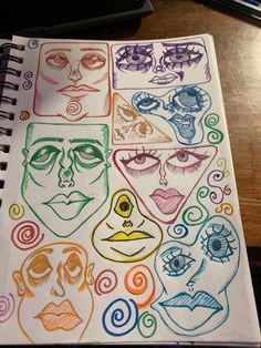 an open notebook with colored drawings of faces and spirals on the cover, sitting on a wooden table