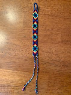 a multicolored paracorre on a wooden floor with a string attached to it