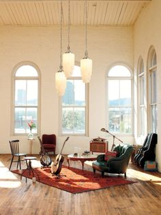 a living room filled with furniture and large windows