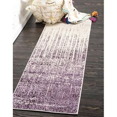 a purple and white runner rug on the floor