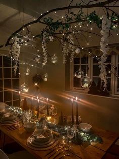 a dining room table with candles and plates on it