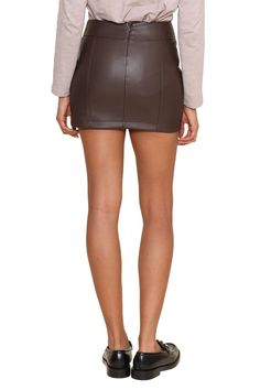 The Carlson Vegan Leather Mini Skirt is a chic and versatile piece that features a high-waisted fit with a sleek, faux leather finish. Its rich burgundy color and subtle side slit add a touch of edge, making it perfect for elevating any outfit from day to night. Pair it with a fitted top and heels for a stylish and polished look. Model is 5'10 and wearing a size XS Face: 100% vegan leather Inside: 100% polyester Machine wash cold Line dry only Fall Knits, Business Chic, Rich Burgundy, Winter Boho, Leather Finish, Jumpsuit Jacket, Leather Mini Skirt, Boho Fall, Fall Accessories