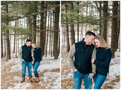 a man and woman standing in the snow near some trees with their arms around each other