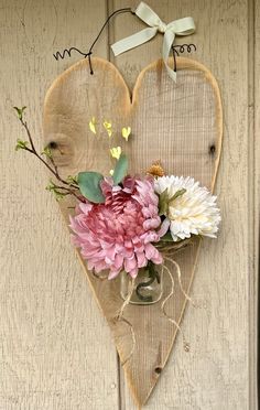 a heart shaped wooden sign with flowers in it