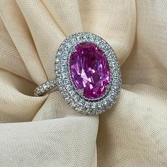 Presenting a gorgeous ring that boasts a 4.29 carat GIA certified oval brilliant cut lab-grown purple-pink sapphire. This eye-catching centerpiece is embraced by a double halo of round-cut lab-grown diamonds, all set in a lovely 14k white gold setting. This ring is more than just a piece of jewelry; it is a symbol of enduring love, refined taste, and commitment to ethical luxury. Whether it's an engagement, an anniversary, or a special occasion, this ring is designed to make a statement and leave a lasting impression. The ring comes with Gemological Institute of America Certificate (GIA Report 6237140455) Metal - 14k White Gold Metal Weight - 6 g Carat Total Weight - 5.44 Center Stone Details: Gemstone - Oval Brilliant Cut Lab Grown Sapphire Measurement - 11.97 x 8.10 x 5.33 mm Carat - 4.2 Luxury Pink Sapphire Jewelry With Center Stone, Luxury Purple Jewelry With Brilliant Cut, Luxury Pink Oval Jewelry, Sapphire Diamond Engagement Ring, Diamond Sapphire Engagement Ring, Sapphire Diamond Engagement, Ring Toss, Edwardian Jewelry, Ring Sapphire