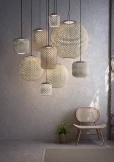 a bunch of lights that are hanging from the ceiling in a room with a chair and potted plant