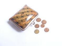 a small purse sitting next to some coins