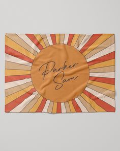 an orange and yellow towel with the words parker sami on it in front of a sunburst