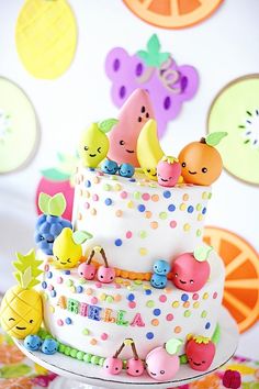 a birthday cake with fruit decorations on it