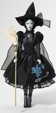 a doll dressed as a witch holding a broom