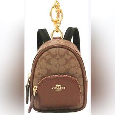 a coach purse with a gold chain hanging from it