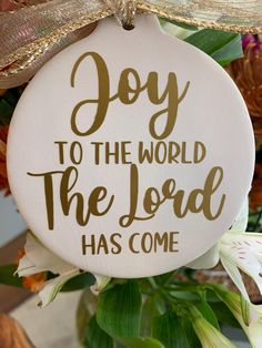 a white ornament with the words joy to the world the lord has come