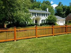 a wooden fence in front of a white house