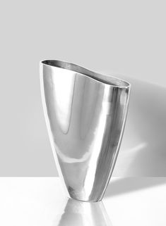 a silver vase sitting on top of a white table