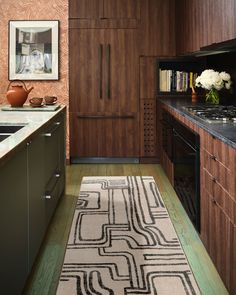 a kitchen with wooden cabinets and an area rug