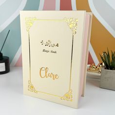 a card with the word love on it sitting next to a potted plant in front of a colorful wall