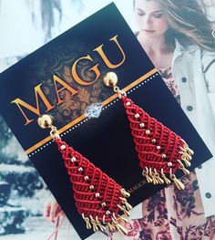 a pair of red beaded earrings sitting on top of a card