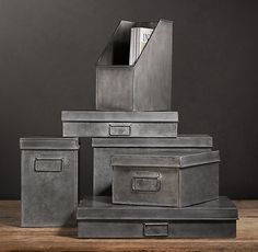 a stack of metal boxes sitting on top of a wooden table next to each other