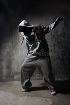 a man in a hoodie is dancing with his arms spread out and hands behind him