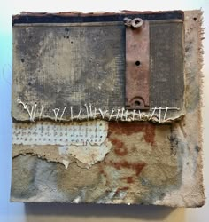 an old piece of paper with writing on it and some rusted metal straps hanging from the side