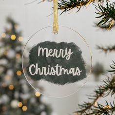 a merry christmas ornament hanging from a tree