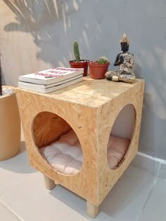 a small wooden table with some books on it and a buddha statue next to it