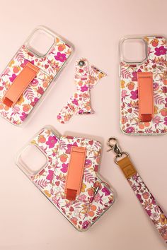 four cell phones with matching cases and lanyards are shown on a pink background