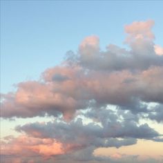 a plane flying in the sky with some clouds